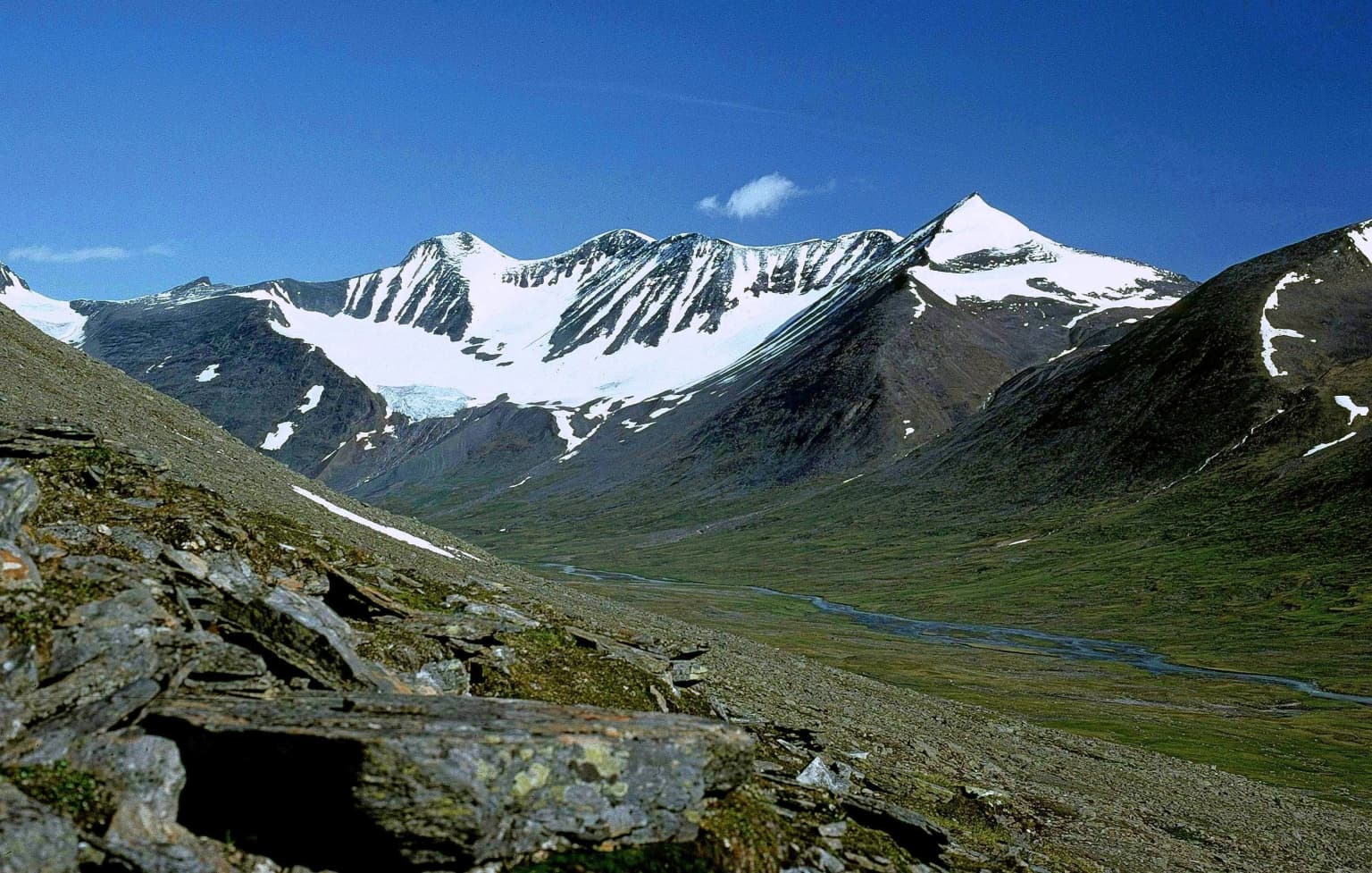 Panoramic view of snow-capped mountains and rocky valley in Sarek National Park, Sweden
