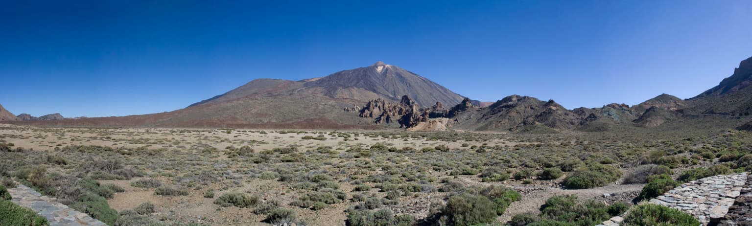 Panoramic view of Teide National Park with Mount Teide (Pico del Teide) in the background, arid landscape, and clear blue sky