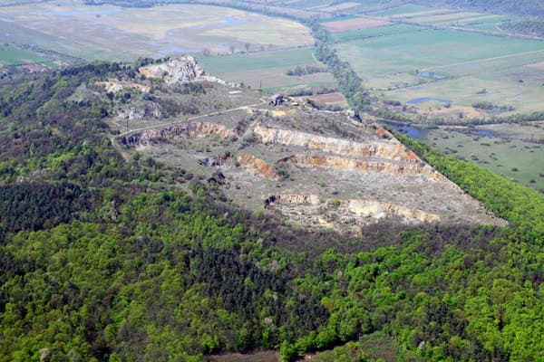 Aerial photograph showing a mountainous landscape with dense forests and open fields in Aggtelek National Park.