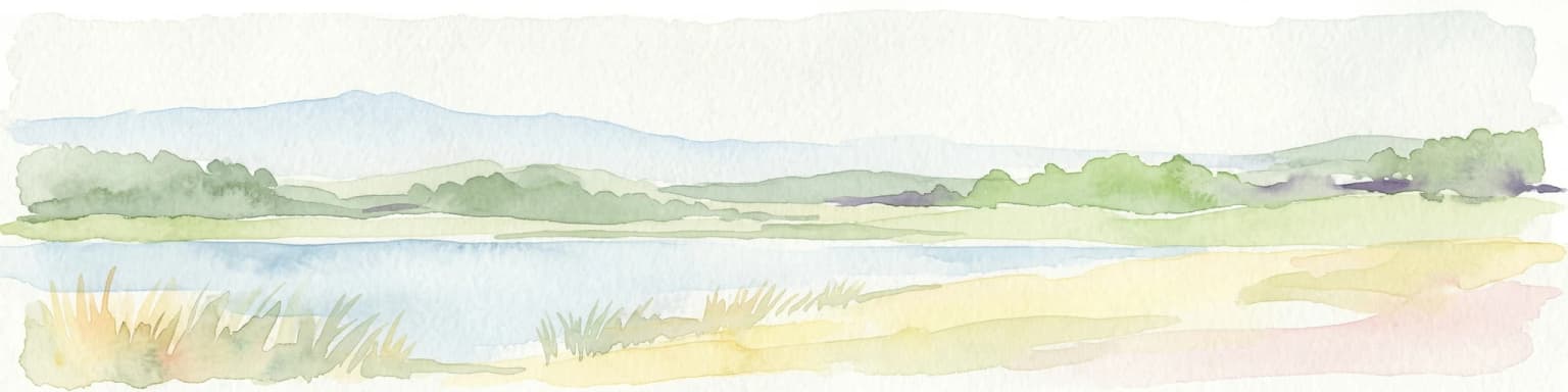 Watercolor painting of a lake, grassy shoreline, distant hills, and trees