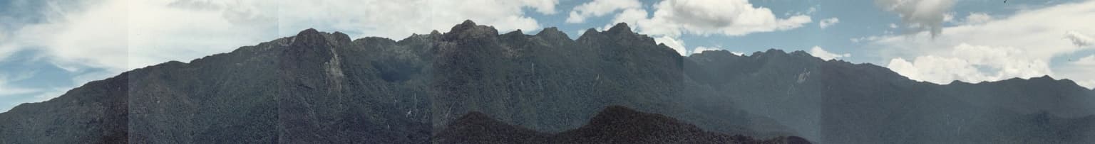 Vista panorámica de picos montañosos con cielo parcialmente nublado