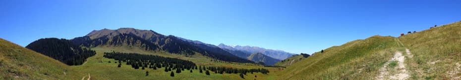 Panoramic view of Kok-Zhaiylau mountain range with green valleys and clear blue sky