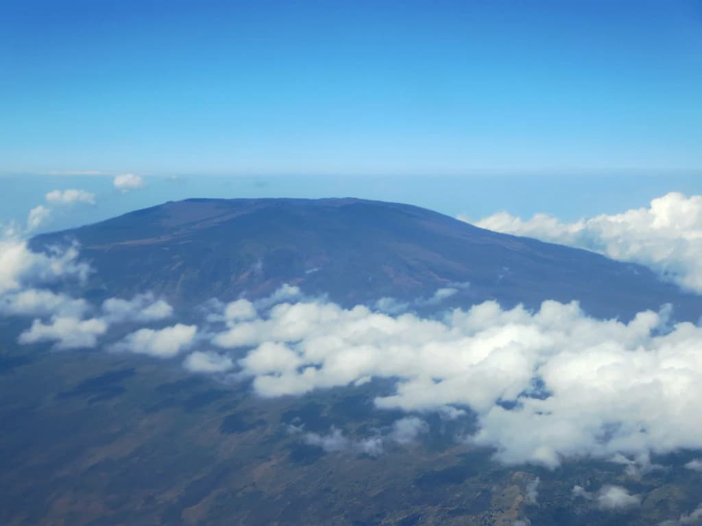Aerial view of Mount Karthala with clouds surrounding the mountain peak