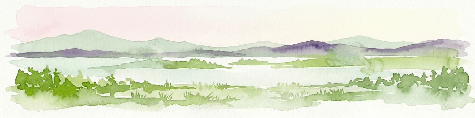 Watercolor painting showing a lake surrounded by forests with mountains in the background