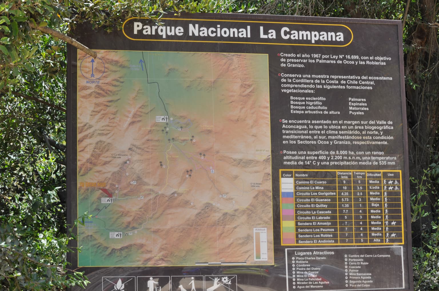 Black signboard displaying map, text, and legend for Parque Nacional La Campana with park details and topographic information