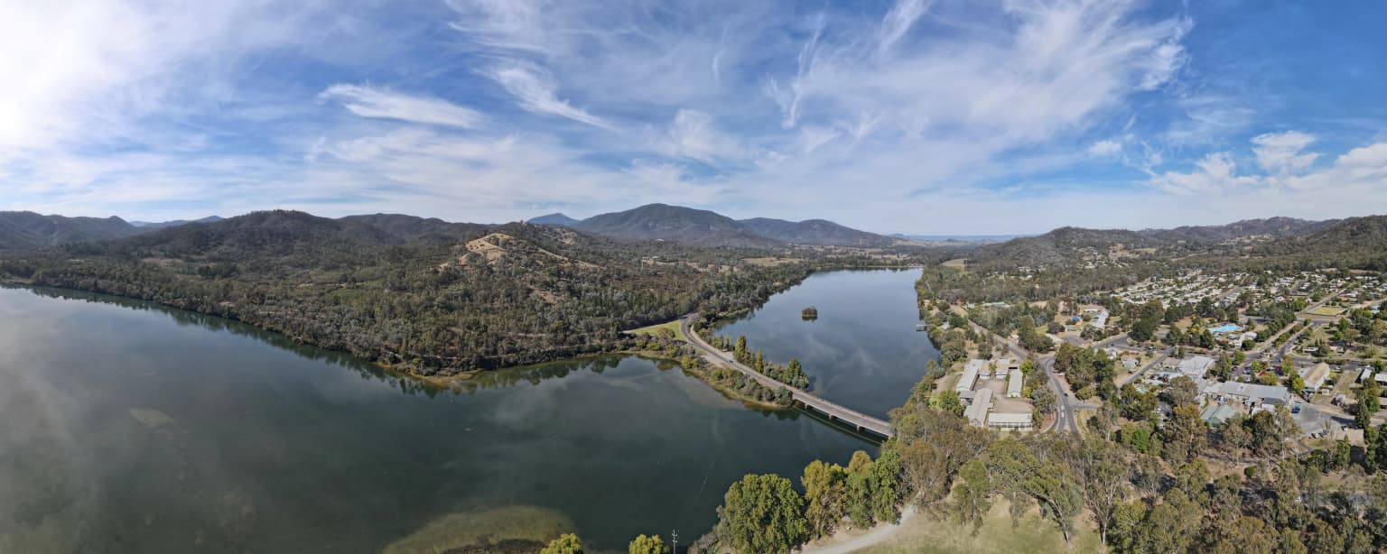 Aerial view of Lake Eildon National Park showing a large body of water, hills, and a bridge