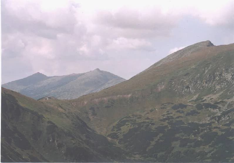 Wide landscape of mountain peaks and valleys under cloudy sky in Low Tatras National Park