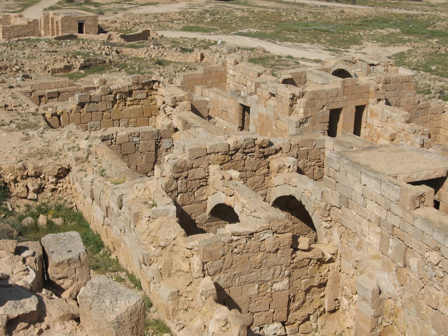 Ruinas de piedra antiguas en el Parque Nacional de Mamshit que muestran muros desgastados, aberturas arqueadas y terreno rocoso en un paisaje árido