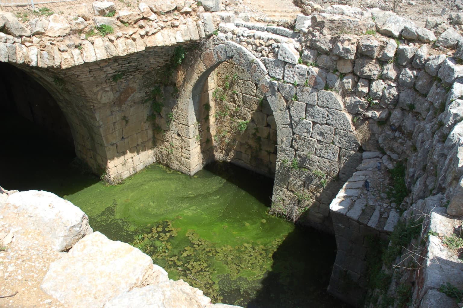 Stone arches of Nimrod Fortress with green water in a moat
