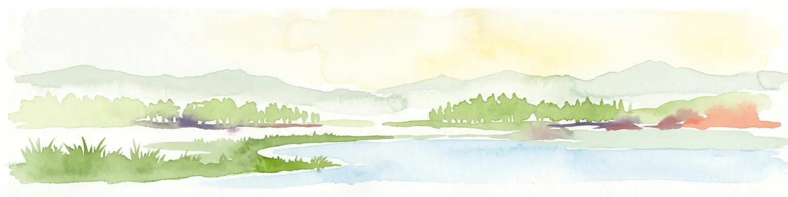 Una pintura horizontal en acuarela que muestra un paisaje suave y brumoso con una masa de agua en primer plano, orillas cubiertas de hierba y colinas onduladas a lo lejos.