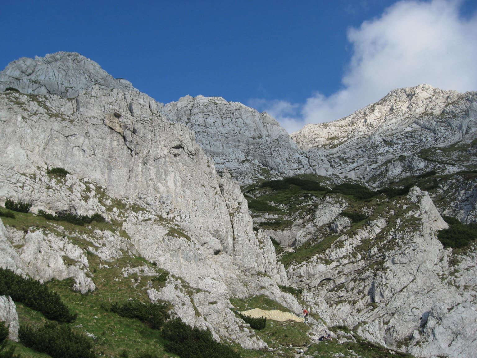 Rocky mountain peaks and ridges with green vegetation under a clear blue sky
