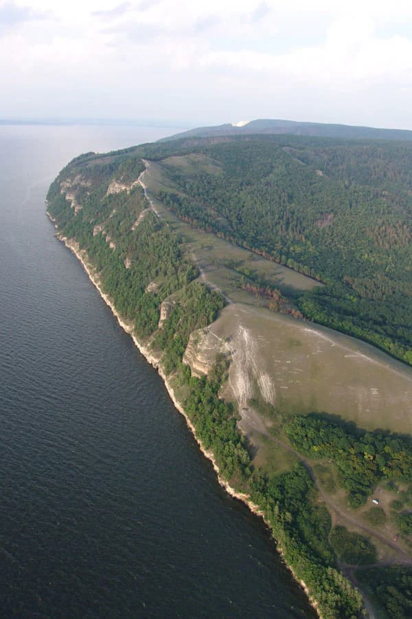 Aerial view of a river with a forested peninsula and a flat-topped hill identified as Molodetsky Kurgan in Samarskaya Luka National Park