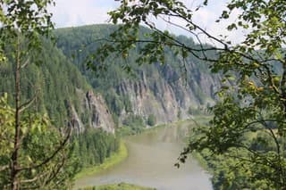 River winding through mountainous landscape with dense forests, viewed from an observation deck