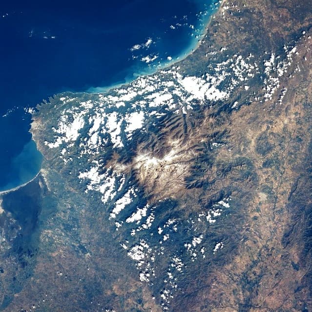 Satellite image showing the Sierra Nevada de Santa Marta mountain range with coastal areas and scattered cloud cover