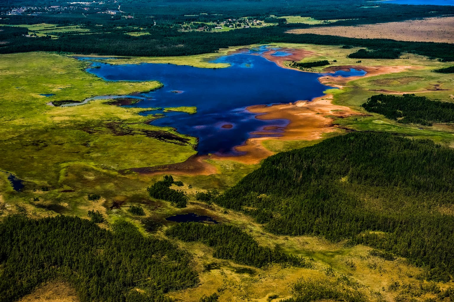 Aerial view showing Kävsjön lake, wetland areas, and forested regions in Store Mosse National Park