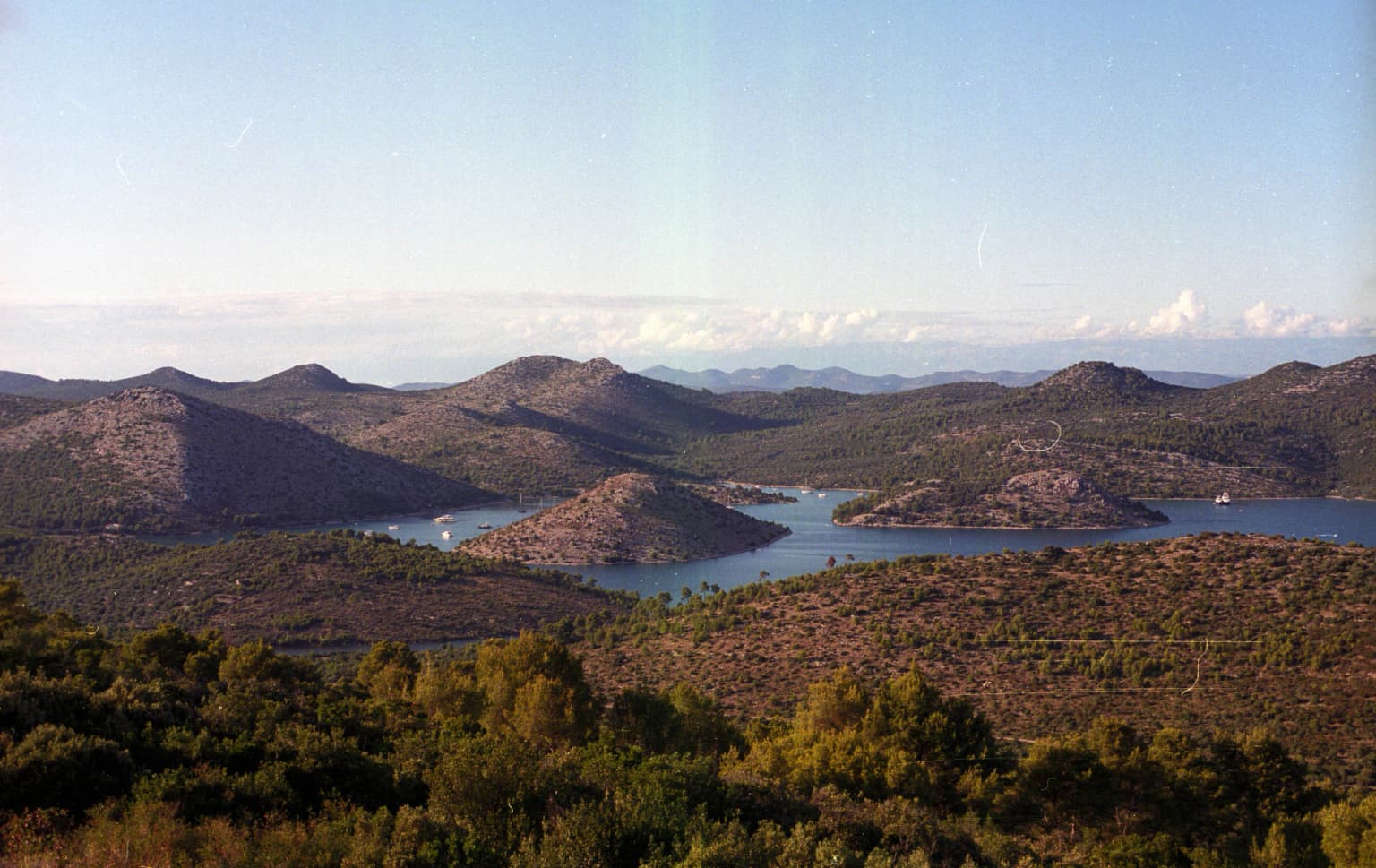 Landscape of Telašćica Nature Park showing hills, coastal waters, and vegetation under clear sky