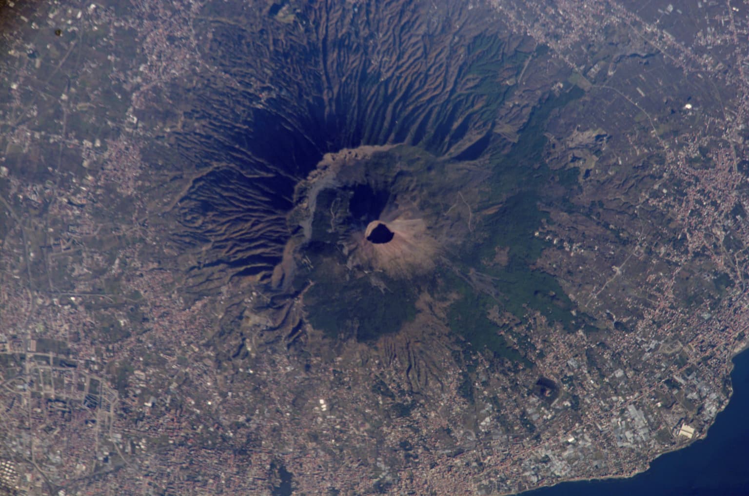 Satellite image of Mount Vesuvius volcano with visible crater and surrounding terrain